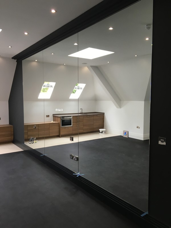 Frameless glass partition in loft conversion by Thornton Heath glaziers
